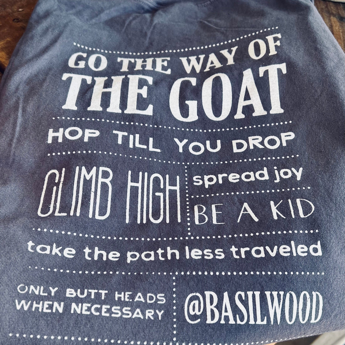 Gray t-shirt with white text on a wooden surface